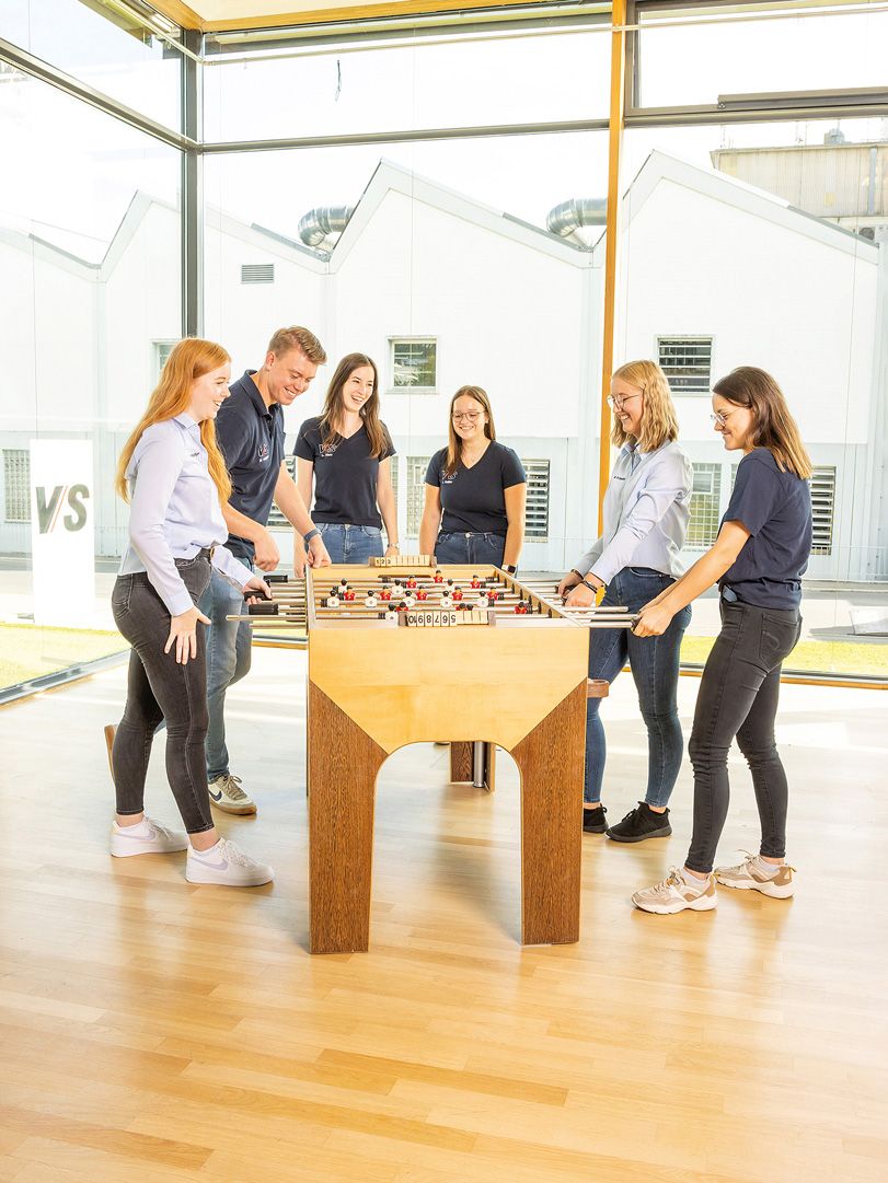 VS apprentices and dual students enjoy their break playing at a wooden football table.