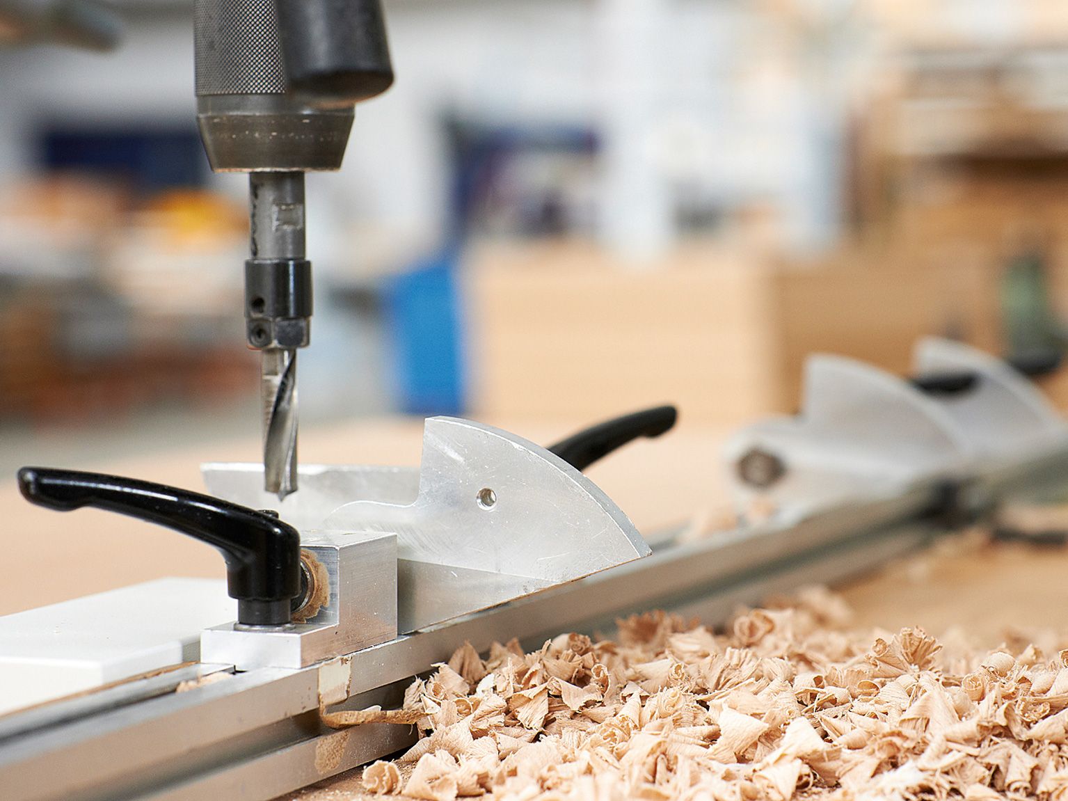 Wood shavings lying next to a wood drill in the manufacturing plant of VS