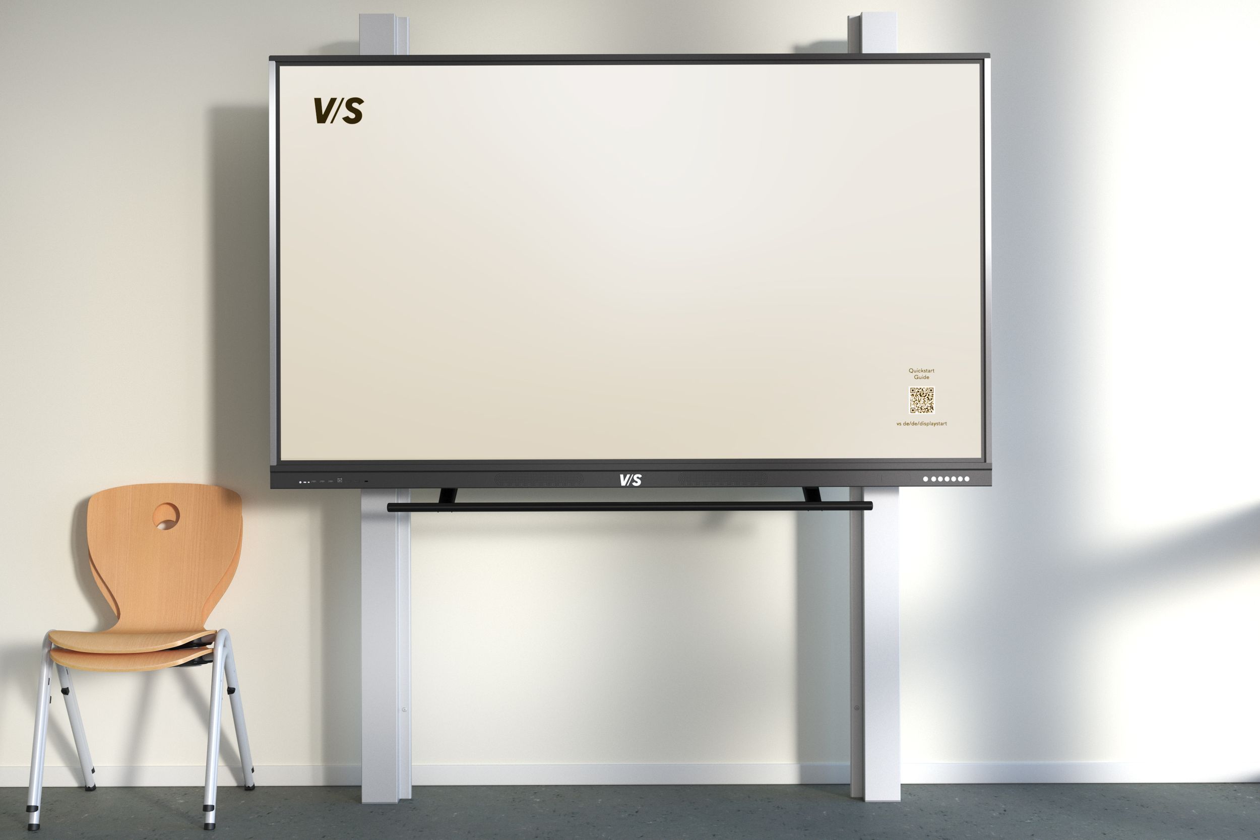 Écran VS monté sur un système de support MediaPilon-GG à contrepoids – réglable en hauteur en continu et sans alimentation électrique, avec à côté une chaise VS Jumper.