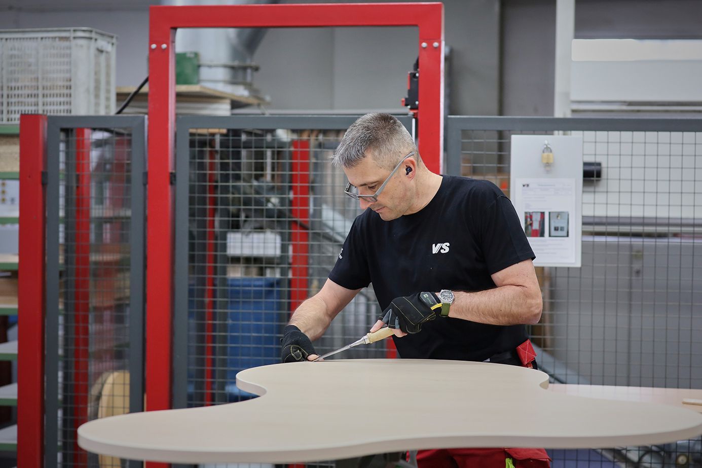 Ein Holzmechaniker arbeitet in der Fertigung am Freiformtisch Puzzle.