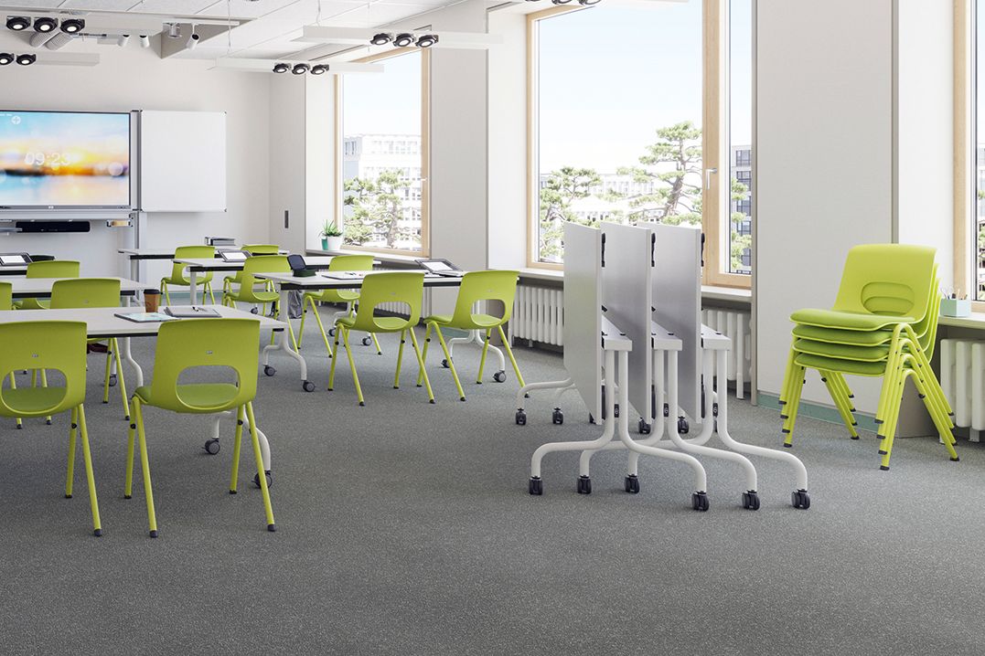 Modernes Klassenzimmer mit den hochklappbaren Tischen FlipTable, den gepolsterten, stapelbaren Schülerstühlen NF-Compass und einem interaktiven Whiteboard MediaPilon von VS