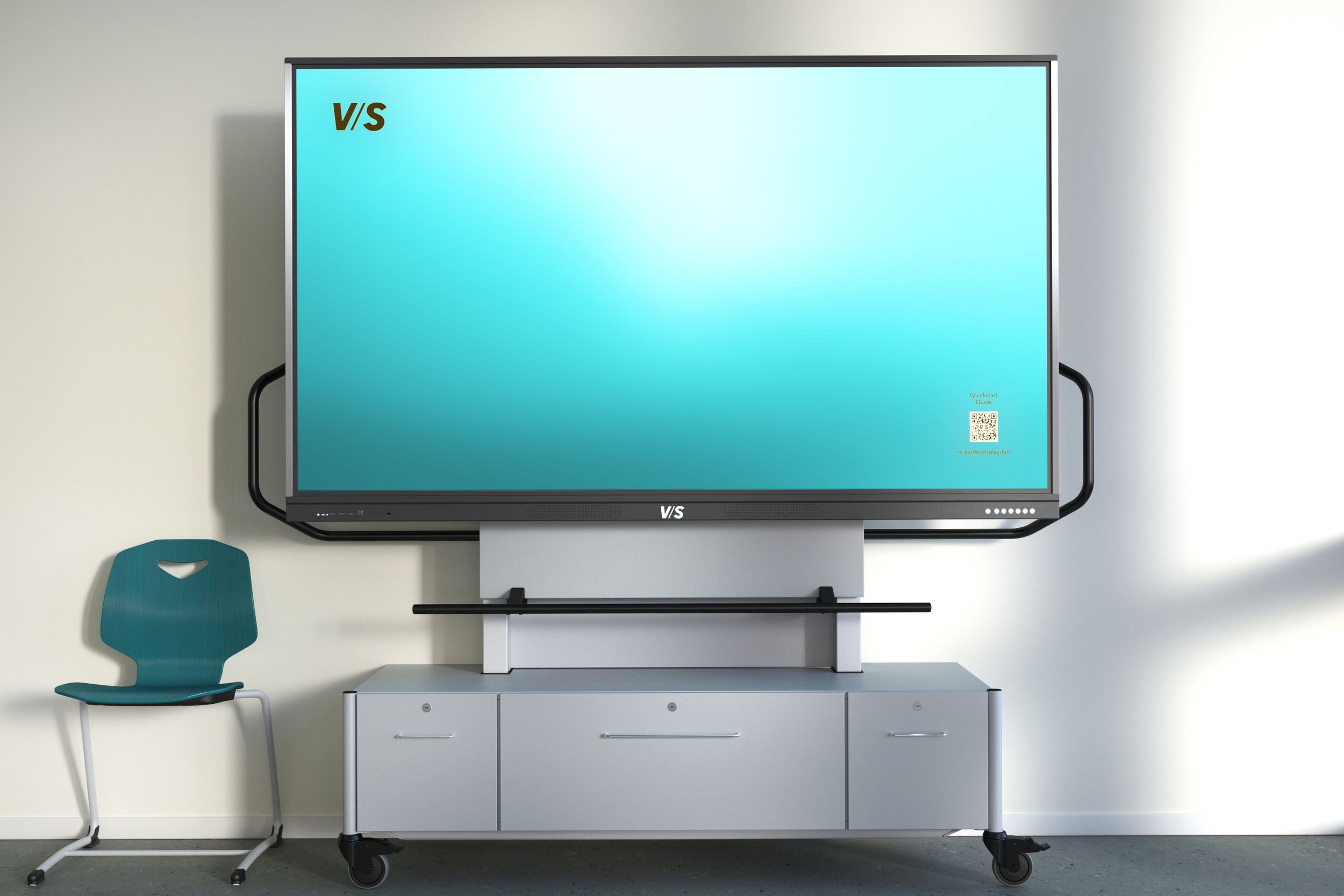 Écran VS sur VS MediaCenter GF 1.0 – système de support mobile à hauteur réglable par vérin à gaz avec espace de rangement intégré, accompagné d'une chaise VS Jumper de couleur bleu sarcelle.