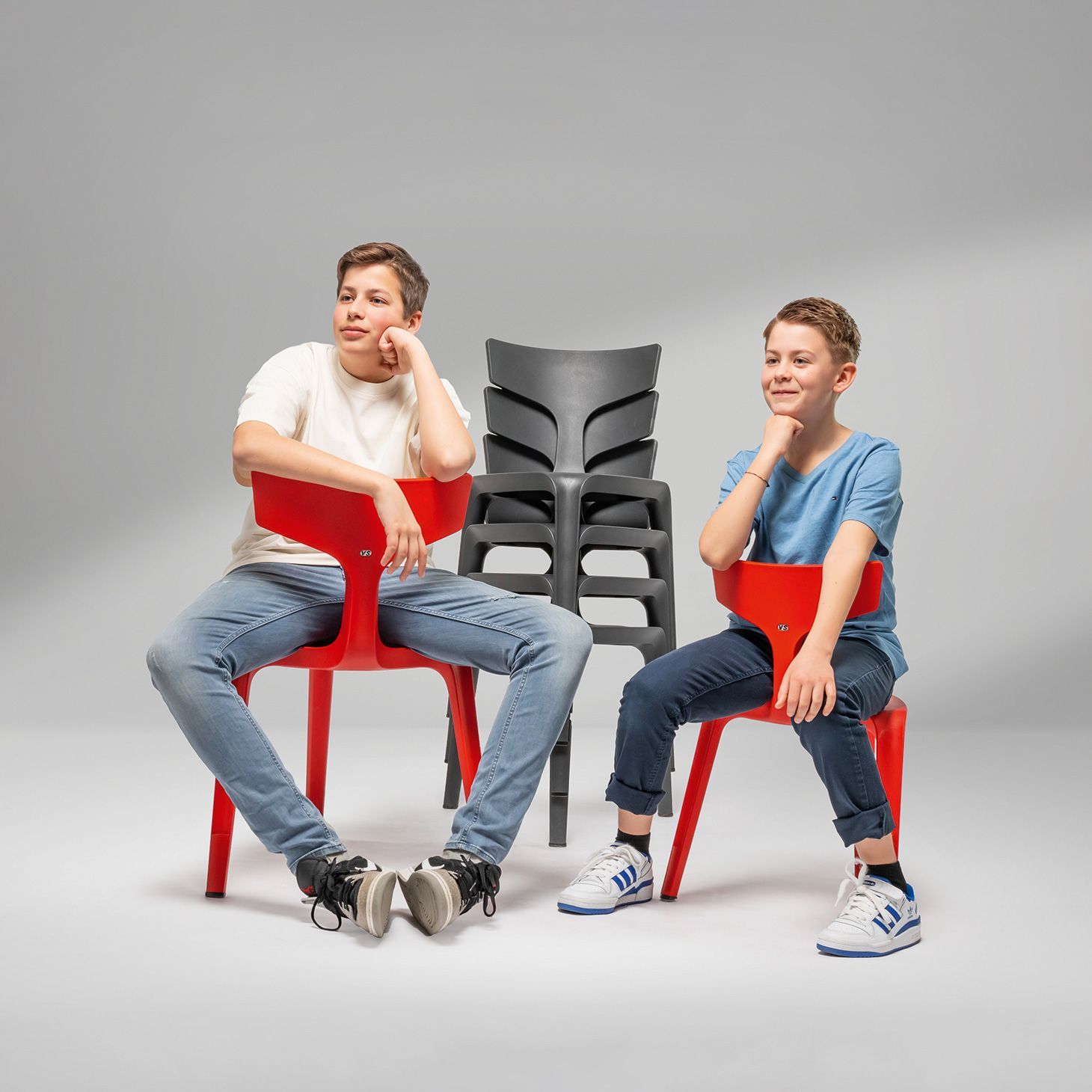 Two boys are sitting on different sized VS chairs Stakki