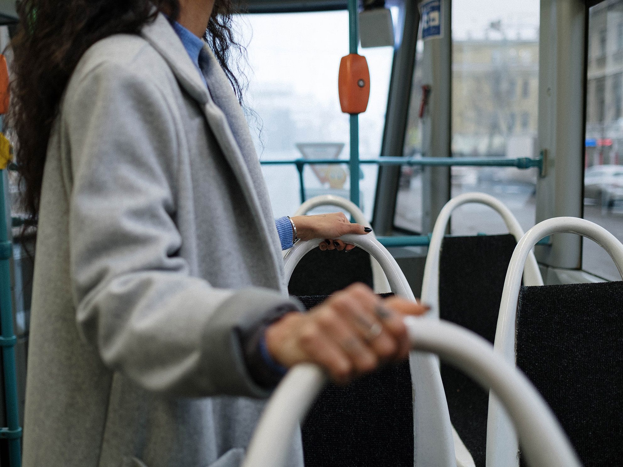 Eine Frau hält sich an Haltegriffen in einem Bus