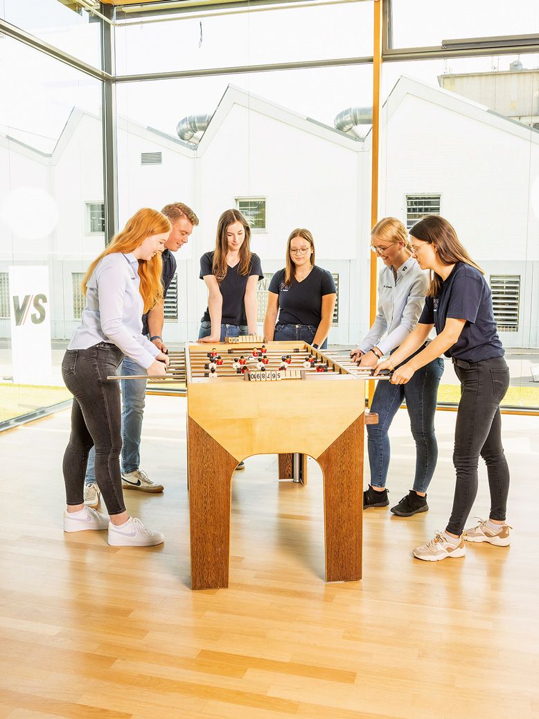 VS apprentices and dual students enjoy their break playing at a wooden football table.