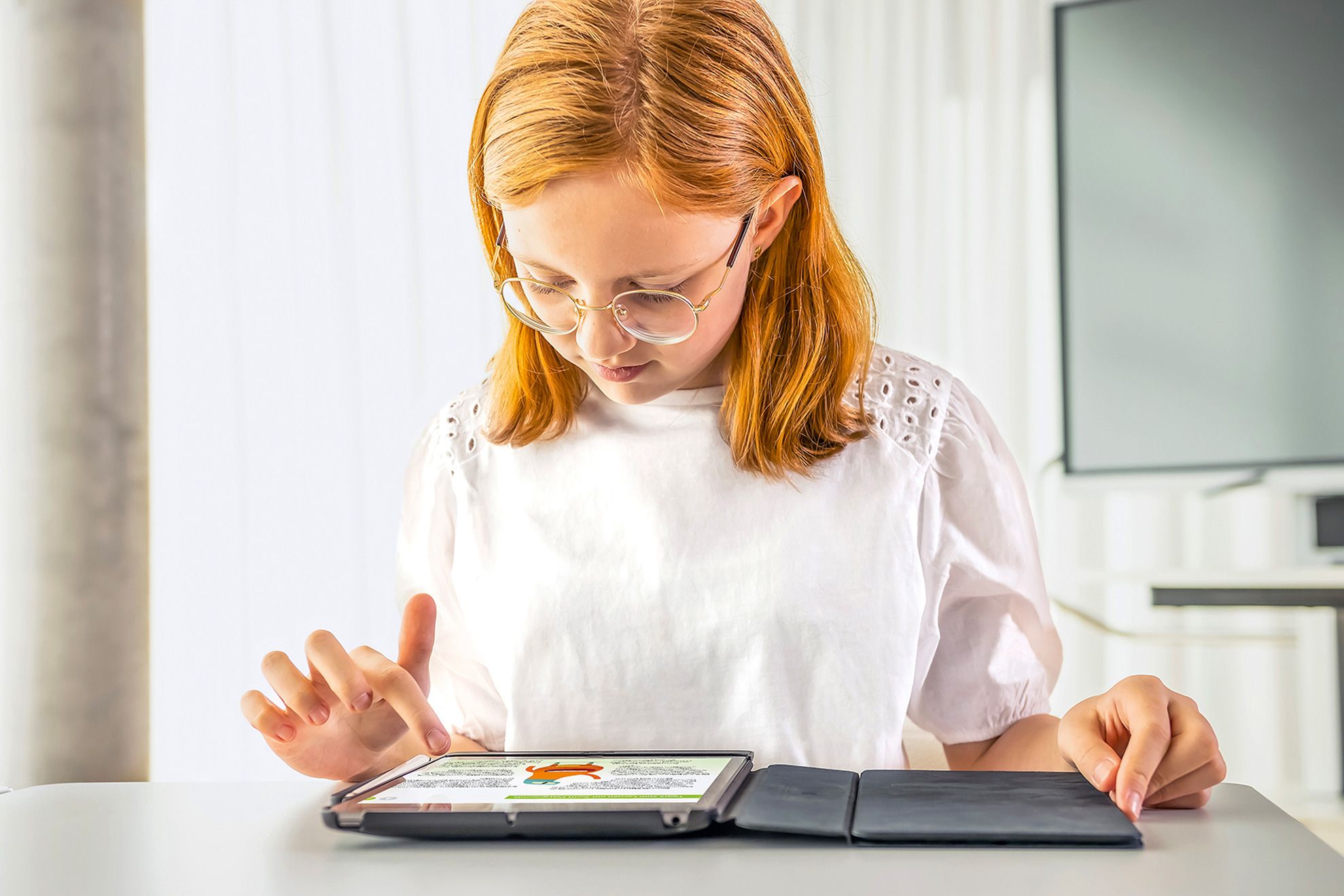 Eine Schülerin interagiert mit einem Tablet, um Inhalte digital zu erlernen.