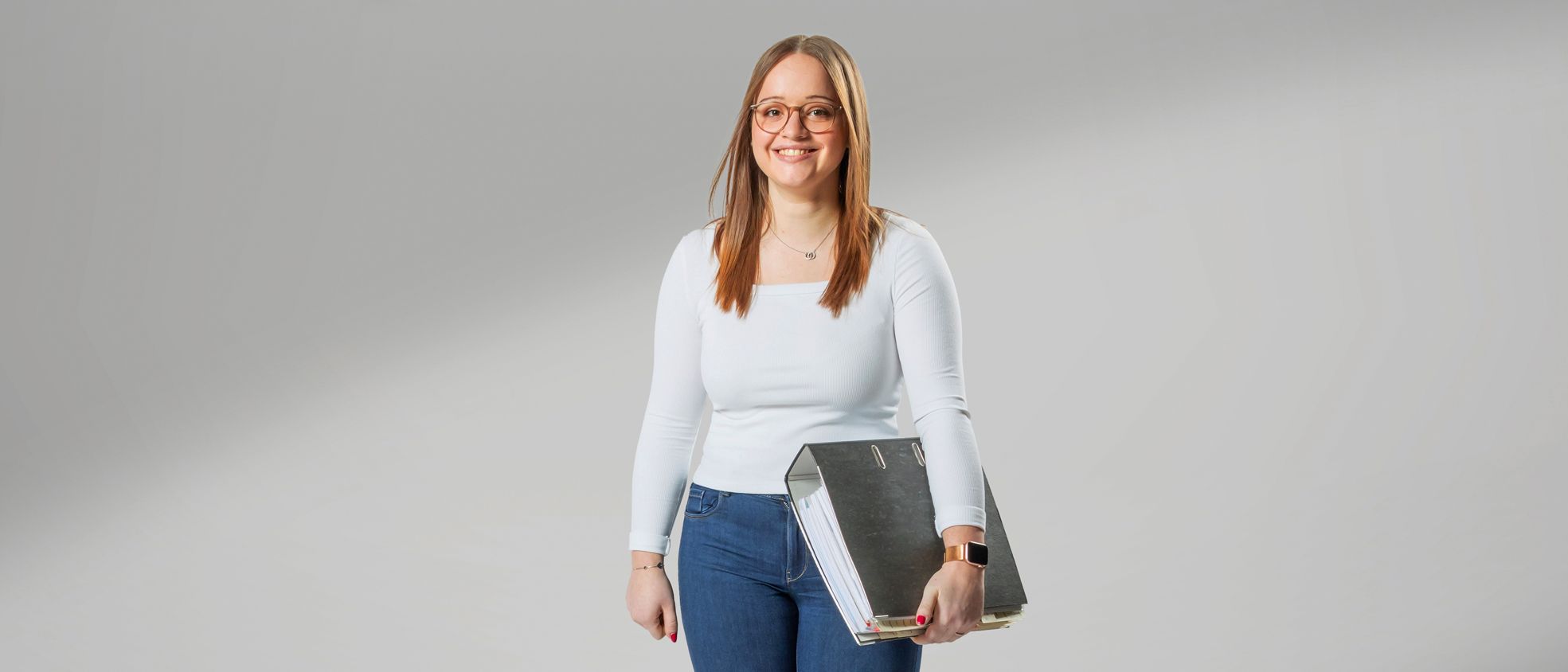 Junge Erwachsene, die eine Ausbildung als Industriekauffrau mit Zusatzqualifikation bei VS macht, lacht in die Kamera.