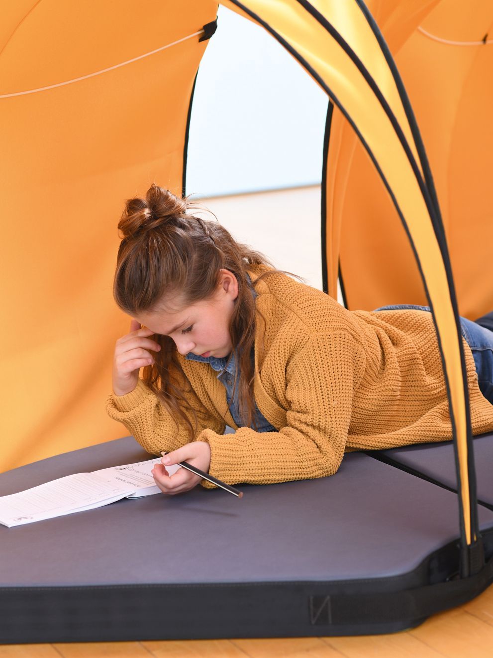 A girl is studying while lying in the tent Leaf by VS.