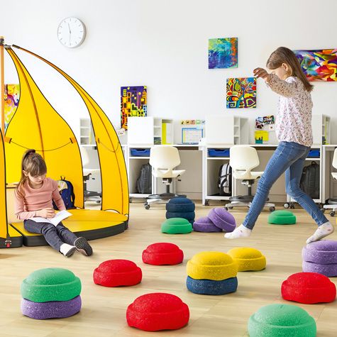 Zwei Mädchen lernen und spielen mit multifunktionalen Bodenelementen wie den Stapelsteinen und dem Zelt Leaf der FloorFriends von VS.