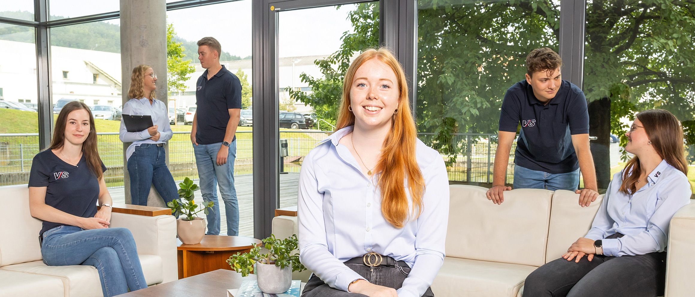 Dual students chat in a relaxed atmosphere in a seating area.