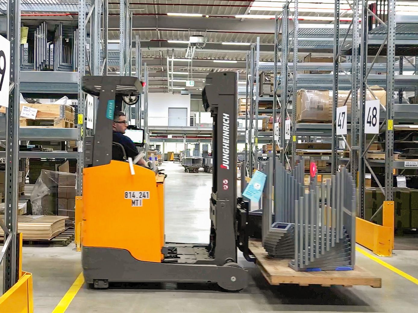 Ein Mitarbeiter von VS fährt mit einem Staplerfahrer durch das Werk.