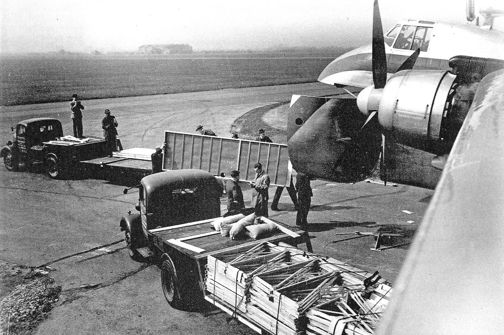 Schwarz-Weiß-Bild von einem Flugzeug aus der Kriegszeit, das beladen wird