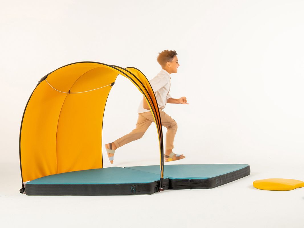 Boy in motion next to tent and padded mats from the VS FloorFriends range