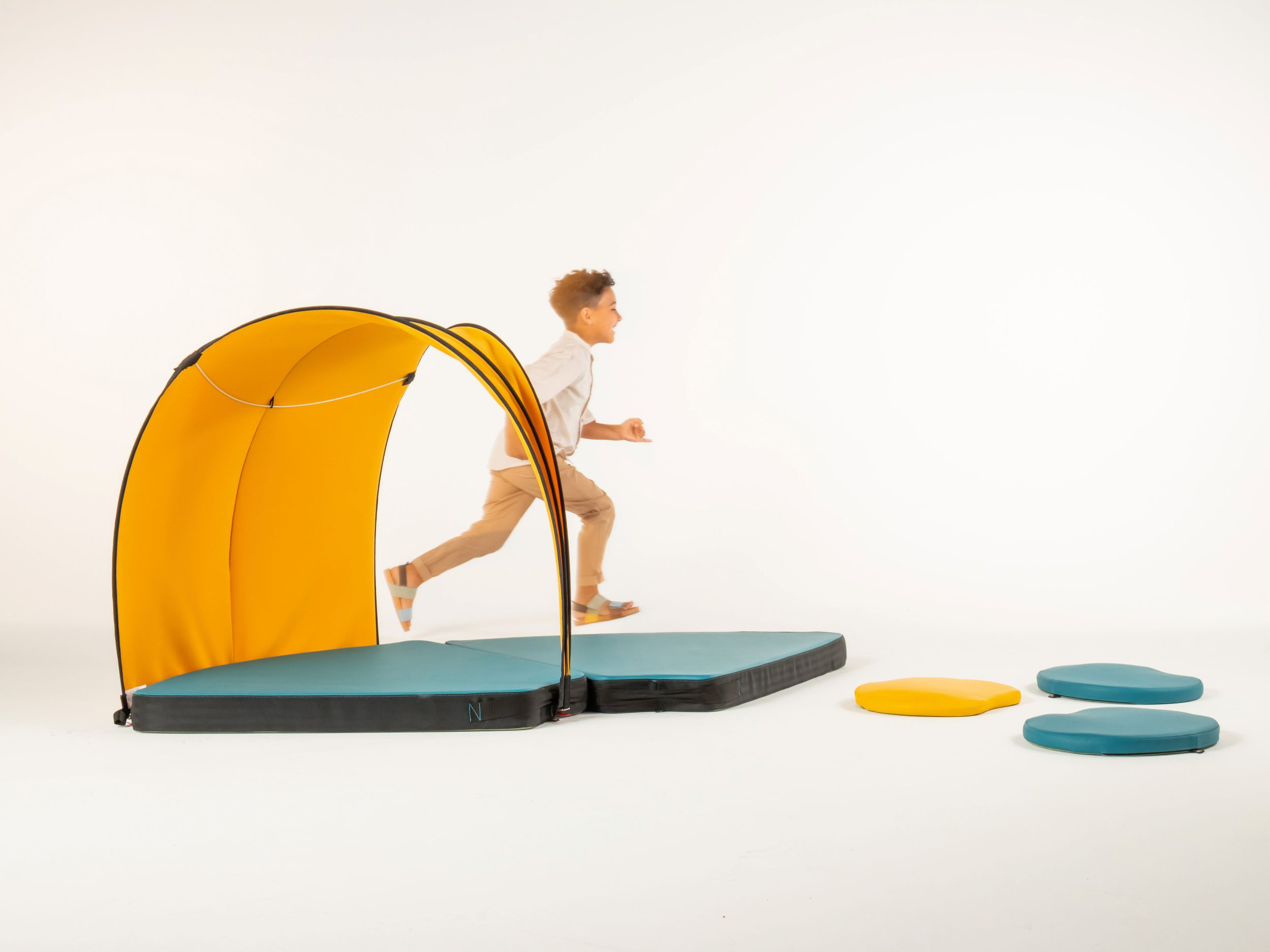Garçon en mouvement à côté de la tente et des matelas en mousse rembourrés de la série FloorFriends de VS