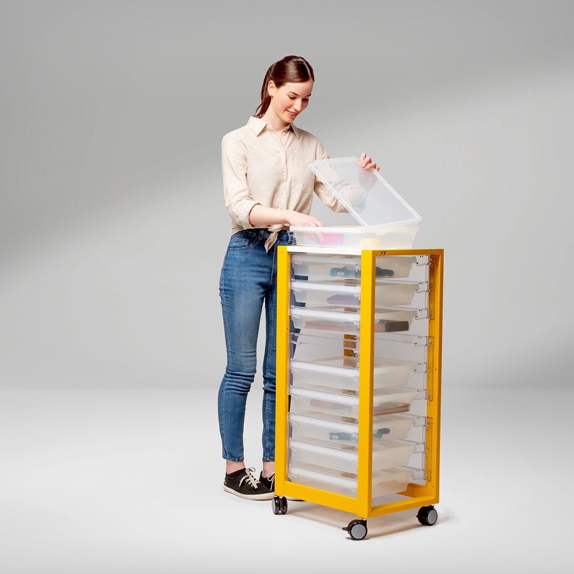 woman has quick access to modular slide-in drawers in a mobile filing cabinet for quick and easy storage