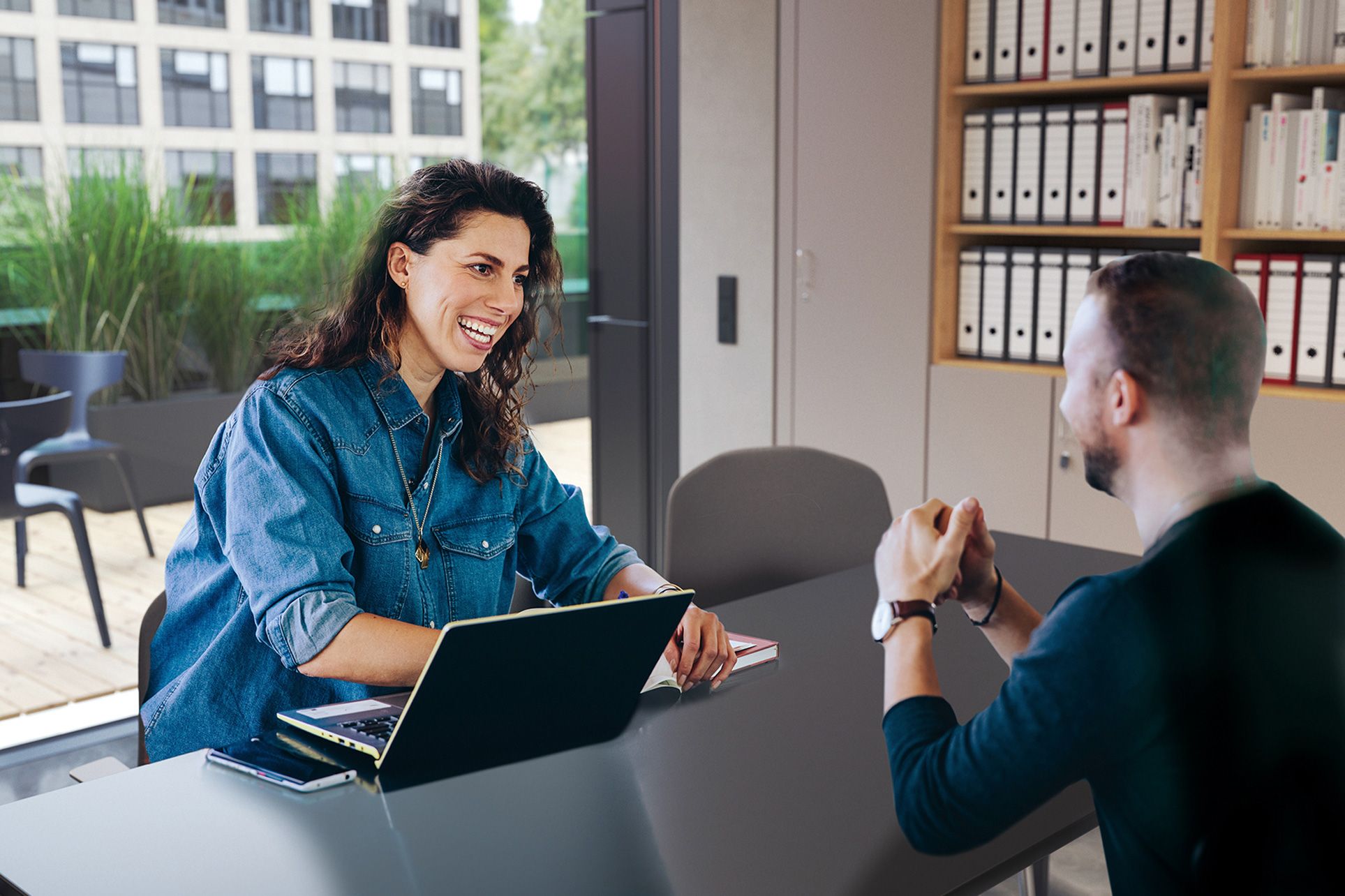 A consultant sits at a table with a customer providing customer service