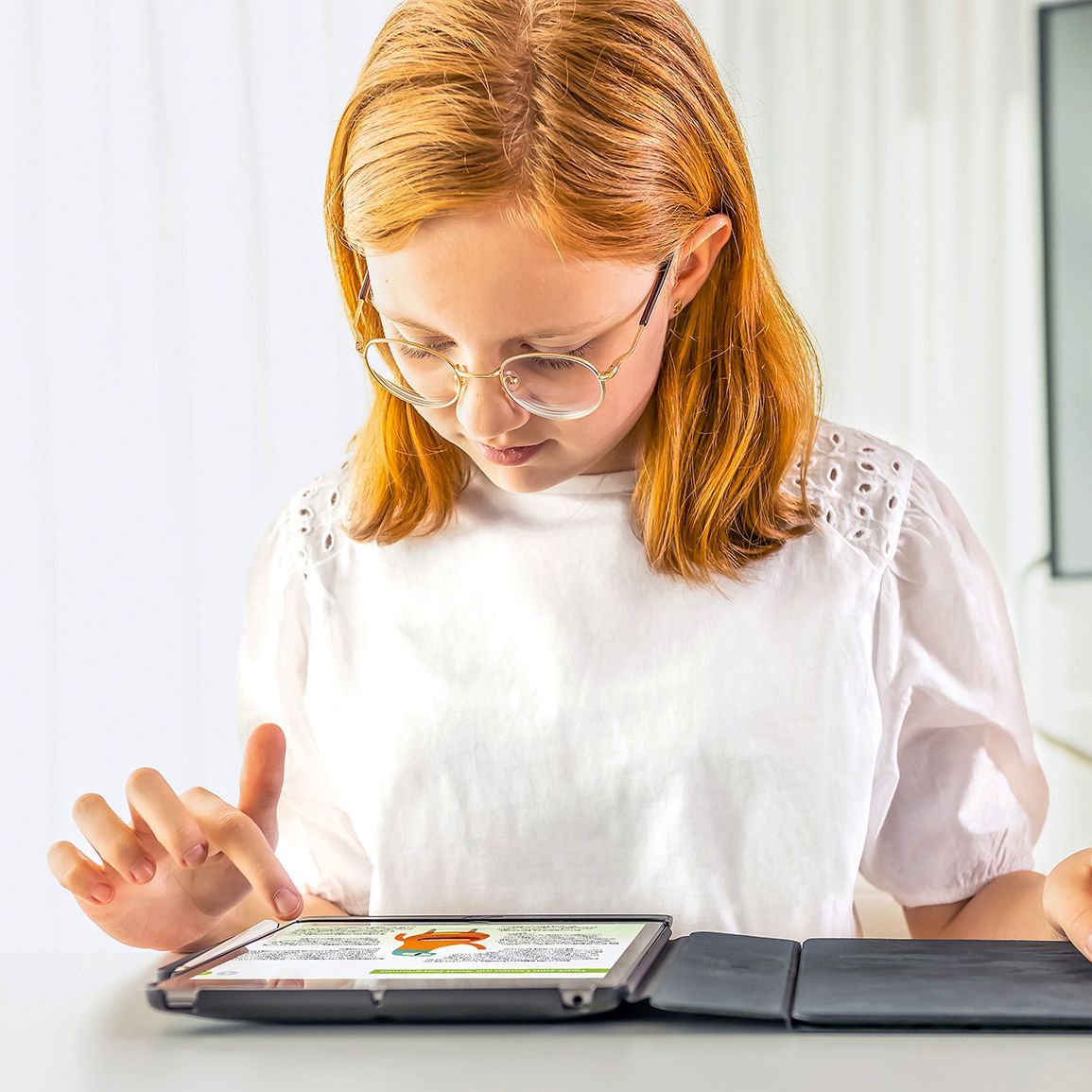 A pupil interacts with a tablet to learn content digitally.