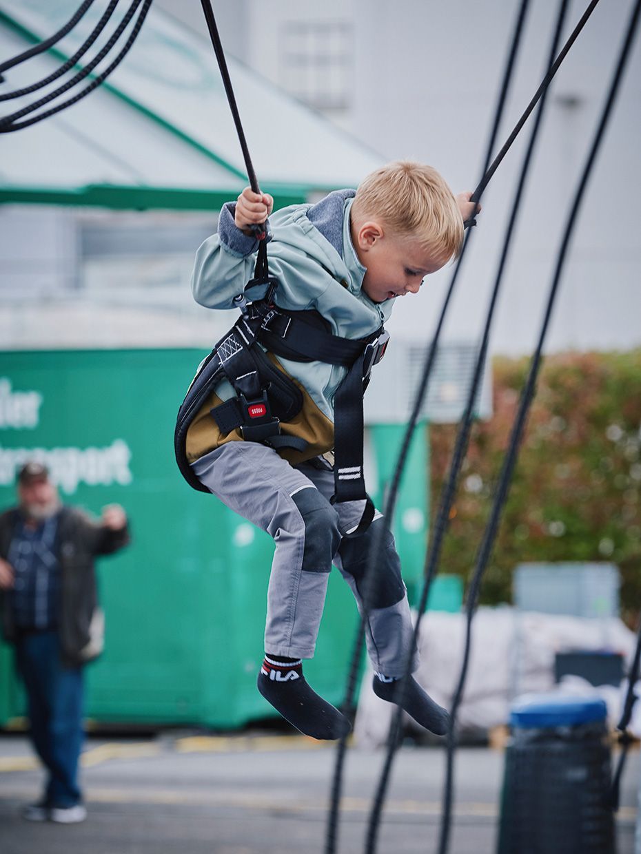 Ein Kind springt auf einem Bungee-Trampolin beim Tag der offenen Tür der VS