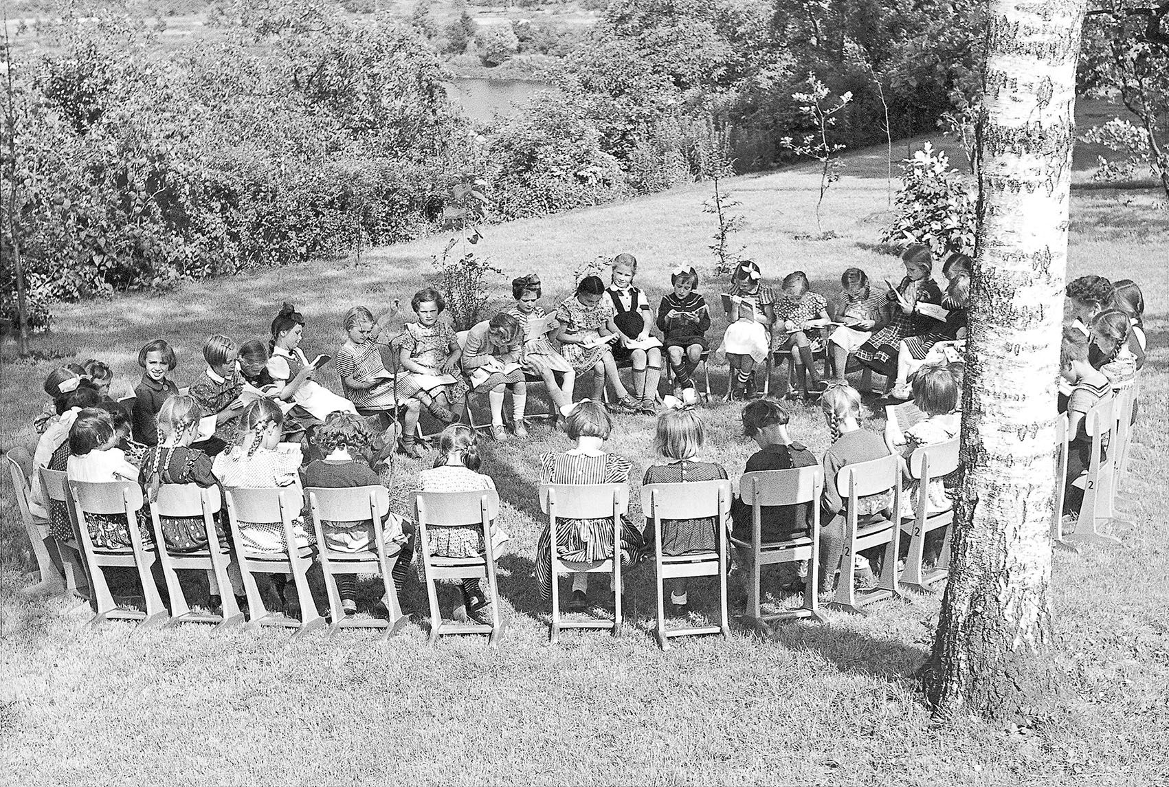 Black and white image of a school class on VS skid chairs in an outdoor seating circle