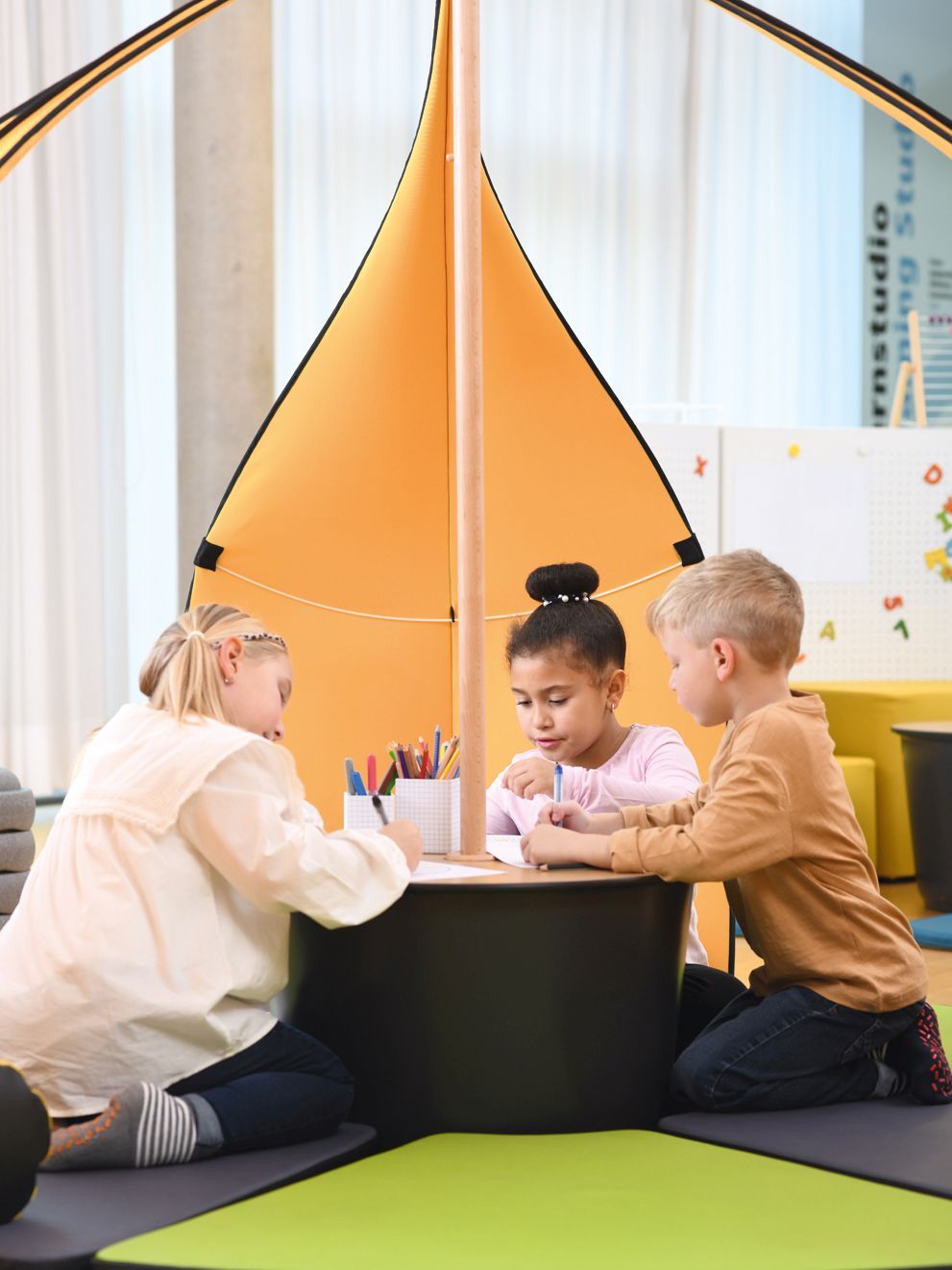 Three children are studying sitting in the tent Leaf by VS.