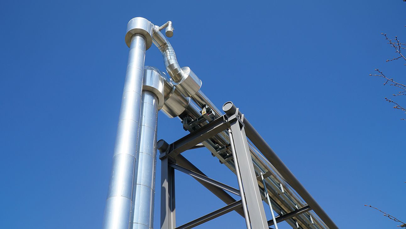 Metal pipes for long-distance heating against a blue sky