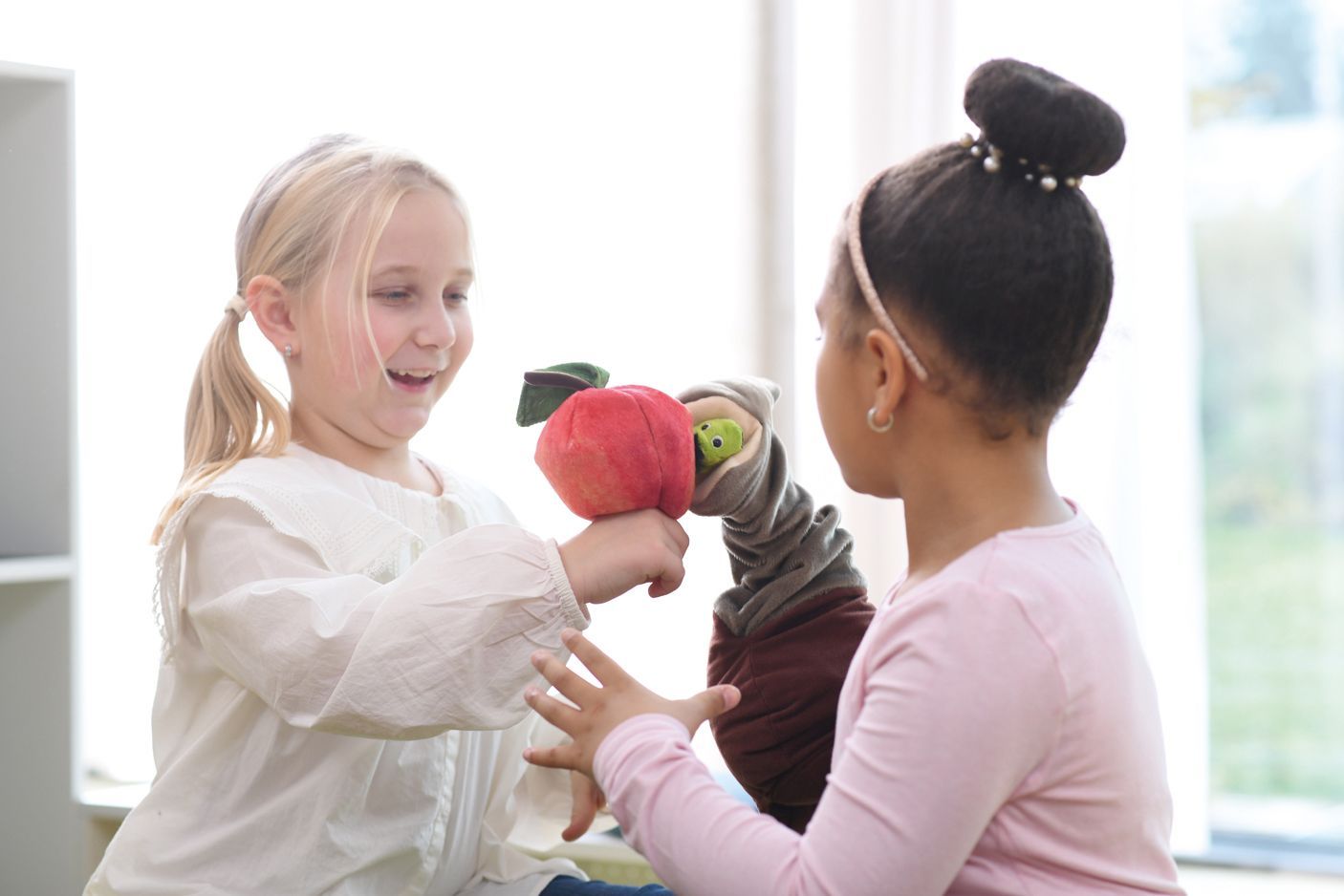 Zwei Kinder spielen mit Handpuppen
