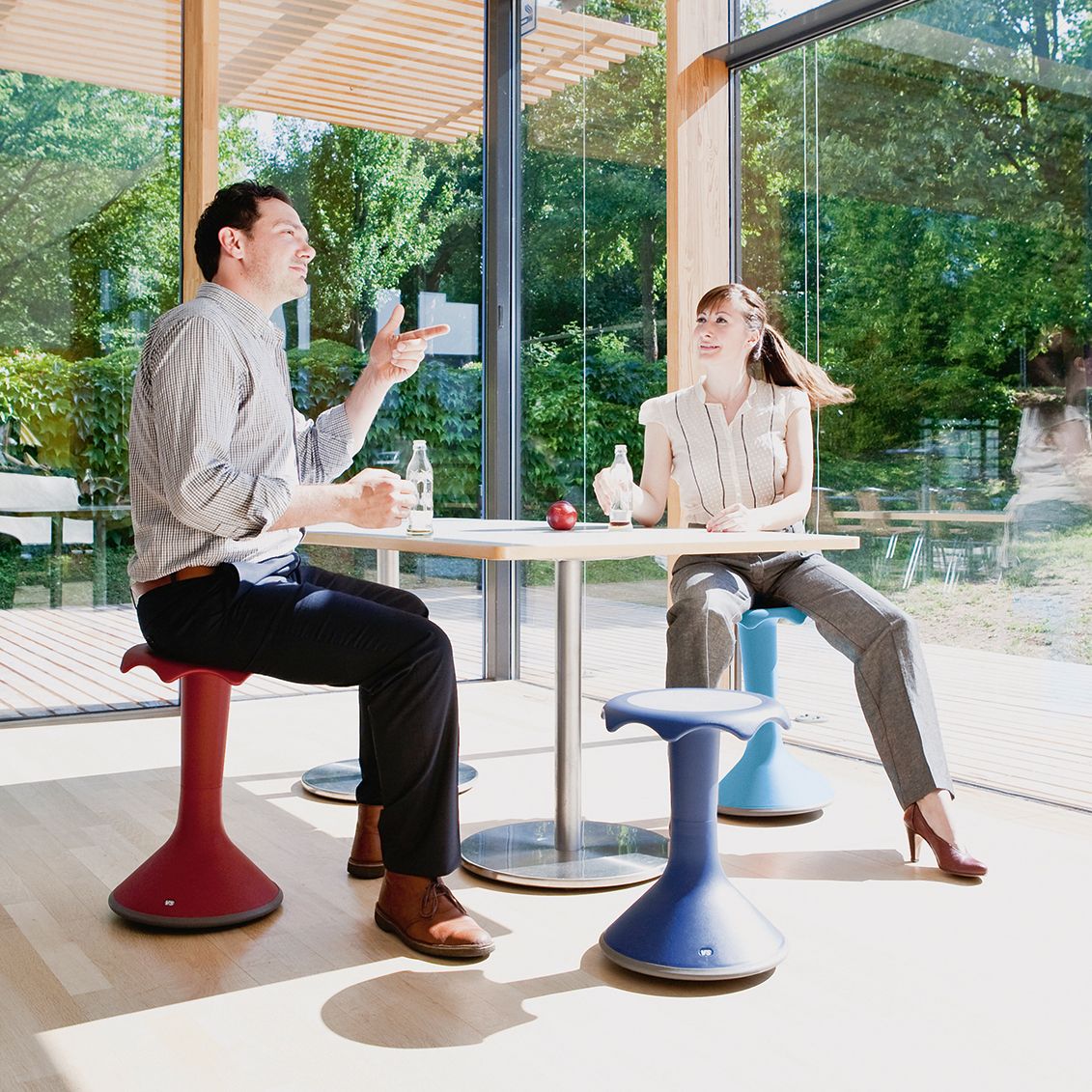 A man and a woman sitting on VS Hokkis at the table are chatting away during their lunch break.