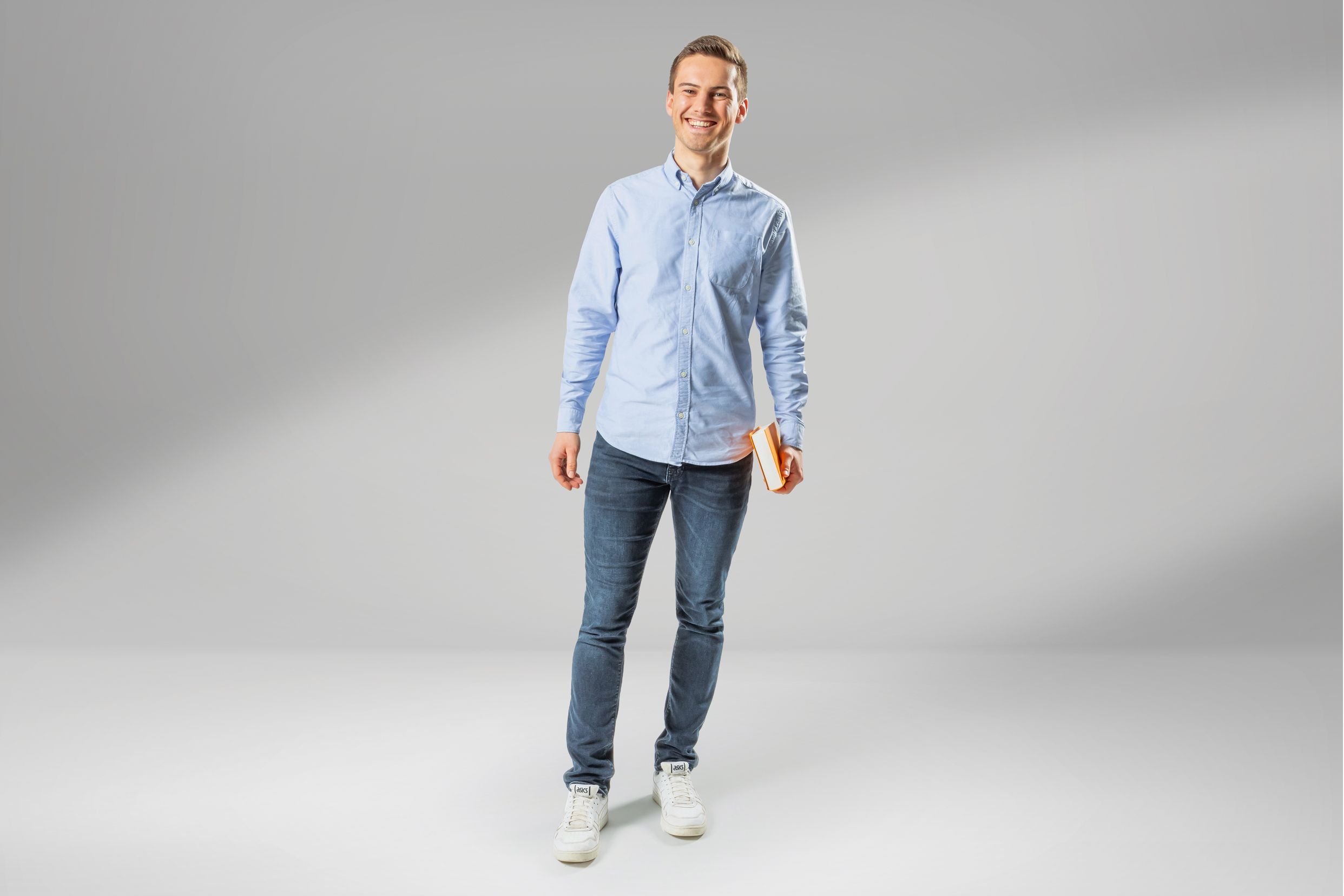 Junger Wirtschaftsingenieur-Student lacht in die Kamera.