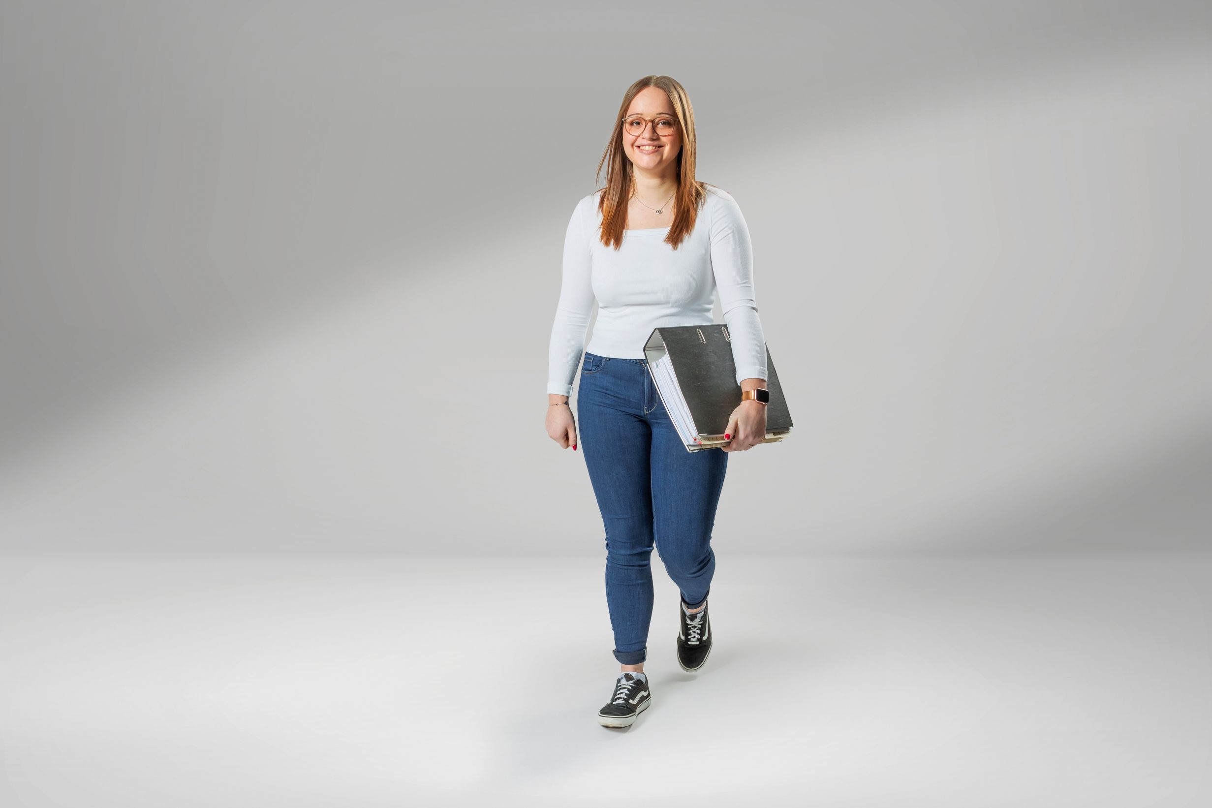 Junge Erwachsene, die eine Ausbildung als Industriekauffrau mit Zusatzqualifikation bei VS macht, lacht in die Kamera.