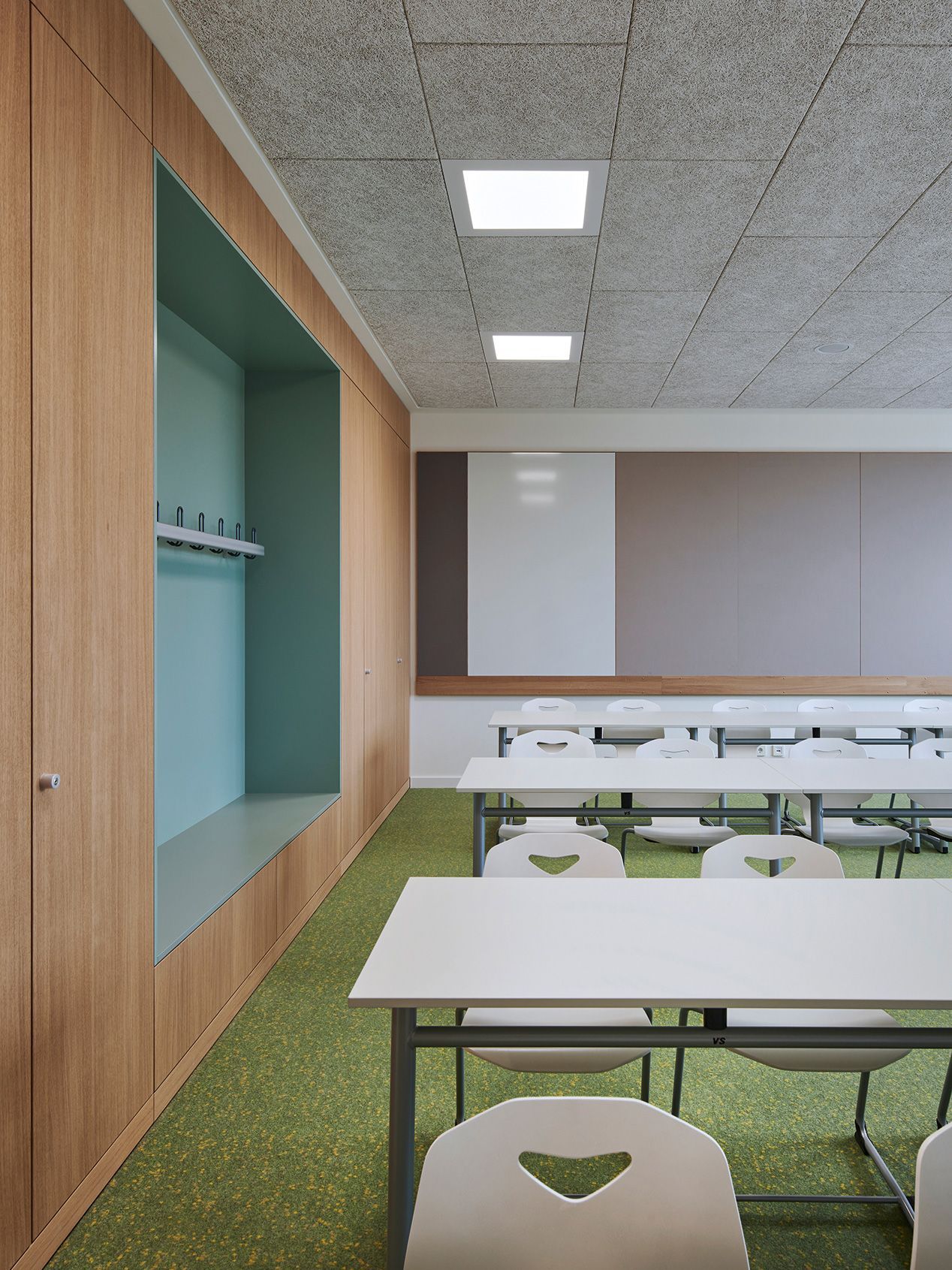 A classroom at the Albert Einstein school in Frankenthal with a coat rack, furnished by VS with Uno-C skid-tables and JUMPER Ply Active students' chairs