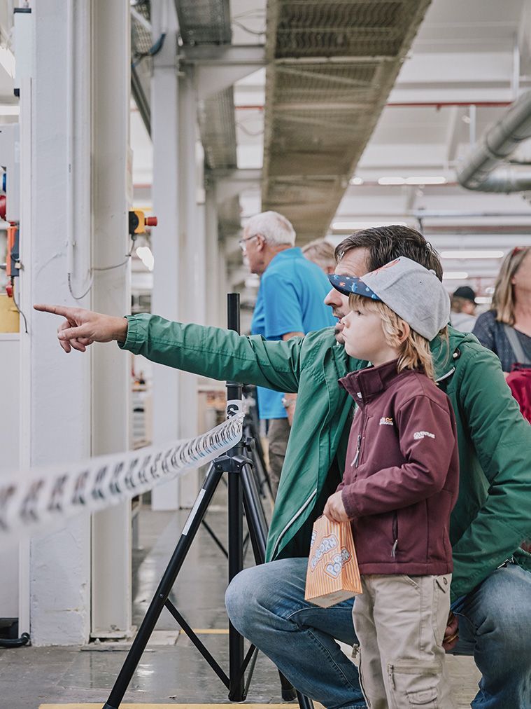 A father shows his son something in Plant 1 at the VS open day