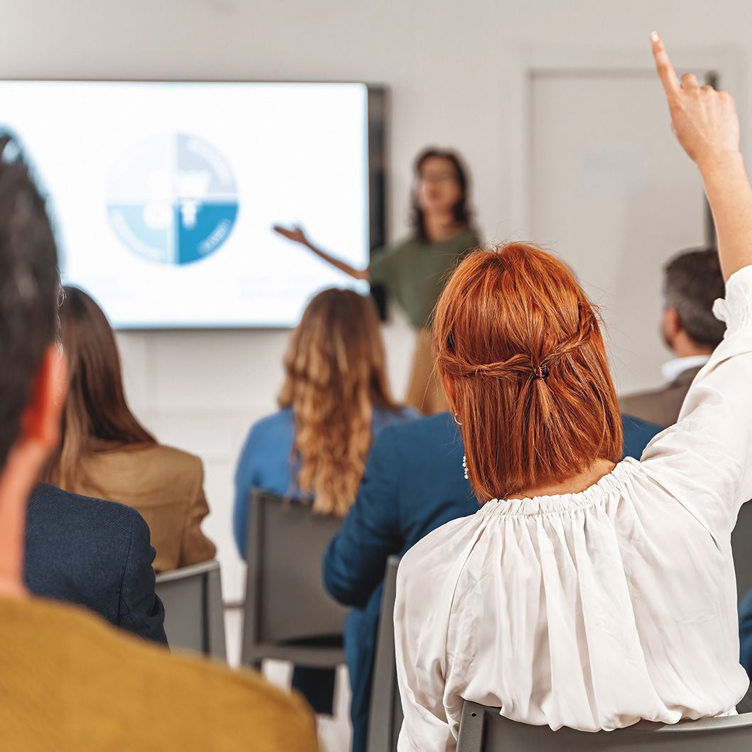 A woman raises her hand during a workshop