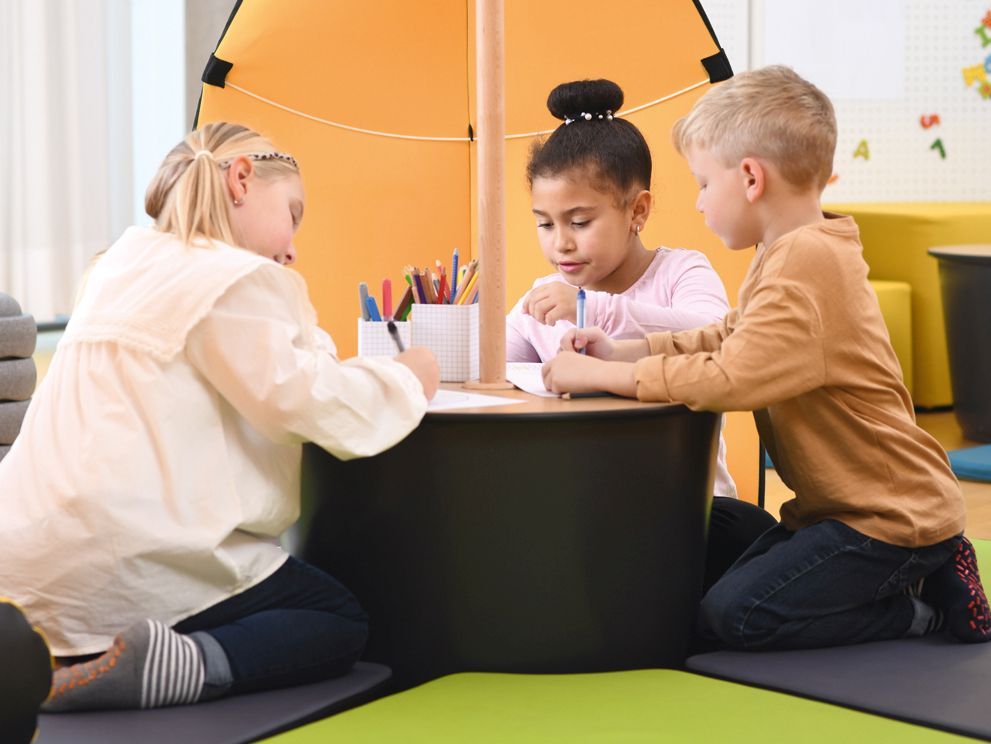 Three children are studying sitting in the tent Leaf by VS.